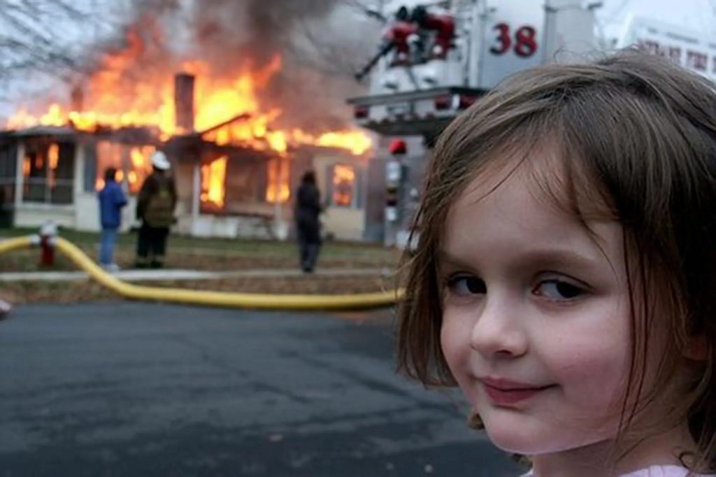 disaster girl, menina sorrindo em quanto ao fundo casas estão sendo incendiadas, simboliza que ao possuir um Plano de Recuperação de Desastres é possível estar tranquilo mesmo em situações adversas